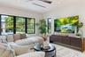 Living space featuring black-framed picture windows, recessed lighting, ceiling fan with wood-finish blades, and custom built-in cabinetry with a curv