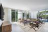 Floor-to-ceiling windows, large-format tile flooring, and a multi-arm geometric chandelier