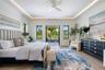 Bedroom featuring a tray ceiling with cove lighting, porcelain-finish flooring, a ceiling fan, and multi-pane windows with glass door access to an ext