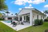 Covered patio featuring board and batten siding, recessed ceiling lighting, attached ceiling fan, and concrete hardscaping surrounding an in-ground sw