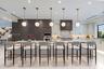 Kitchen featuring a large central island with waterfall-edge stone countertop, custom cabinetry, integrated professional-grade appliances, recessed li