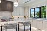 Kitchen featuring flat-panel cabinetry, a stone-surfaced island and countertops, a custom slatted wood range hood, a professional-style gas range, and