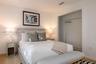 Room featuring recessed lighting, wood-finish flooring, and an open reach-in closet with an integrated metal hanging rod