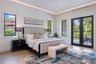 Tray ceiling with integrated recessed lighting, light-toned porcelain-finish flooring, and black-framed windows and dual-lite French doors