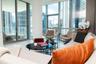 Floor-to-ceiling windows, polished stone flooring, and expansive glass balcony doors