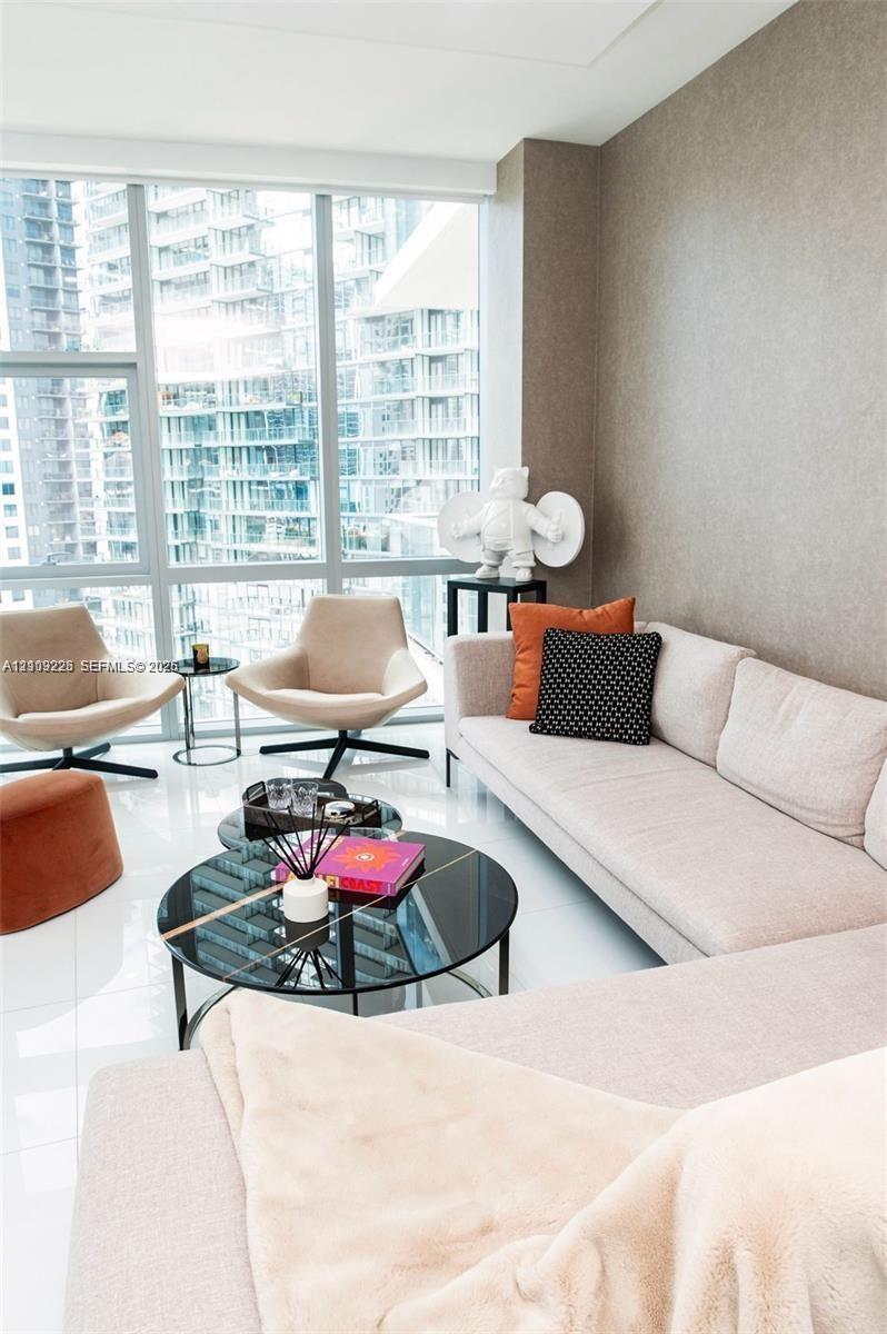 Floor-to-ceiling windows with expansive glass panels, high-gloss tile flooring, and a neutral-toned feature wall