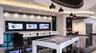 Custom entertainment area featuring high-gloss flooring, recessed circular ceiling treatments with pendant lighting, a textured accent wall, and a bui