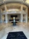 Grand lobby featuring floor-to-ceiling stone wall cladding, polished stone tile flooring with decorative inlay, a multi-level architectural recessed f