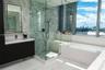 Modern floating vanity with a stone countertop, floor-to-ceiling glass-enclosed shower featuring stone wall tile and an integrated bench, deep soaking