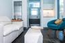 Kitchenette featuring white cabinetry, integrated sink, and stainless steel refrigerator