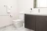 Modern floating vanity with a solid-surface countertop and integrated sink, complemented by a dual-tone charcoal cabinet, chrome-finished wall-mounted