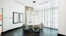 Double-height ceilings featuring floor-to-ceiling windows with full-length drapery, large-format tile flooring, and a statement spherical chandelier