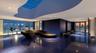 Custom organic-shaped ceiling architecture featuring a large skylight, expansive floor-to-ceiling glass paneling, and polished stone flooring