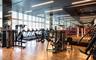 Fitness center featuring wood-finish flooring, floor-to-ceiling windows, mirrored walls, recessed linear lighting, and a raised boxing ring
