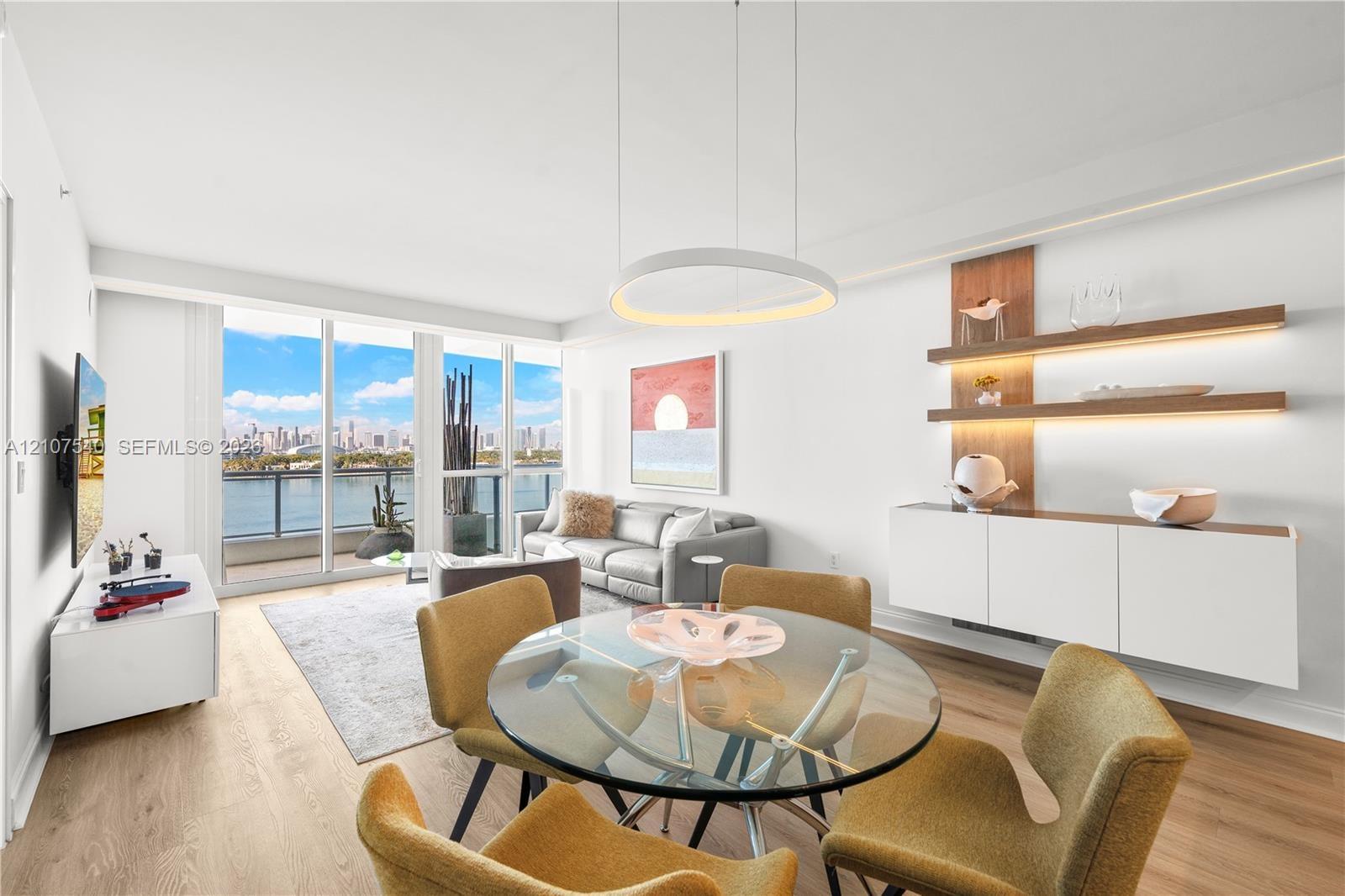 Open-concept living space featuring floor-to-ceiling windows, wood-finish flooring, modern circular LED integrated lighting built into custom soffits,