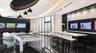 Custom circular tray ceiling with recessed lighting, black gloss tile flooring, floor-to-ceiling glass wall, built-in bar with stone countertop, and d