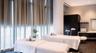 Floor-to-ceiling windows with full-height drapery, dark wood-finish flooring, built-in cabinetry, and integrated vanity with undermount sink