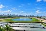 Aerial perspective featuring a racetrack, central water feature, and expansive skyline backdrop