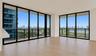Floor-to-ceiling windows with black frames, wood-finish flooring, and expansive wrap-around balconies