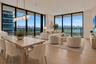 Floor-to-ceiling windows, wood-finish flooring, linear pendant lighting, and private balcony access
