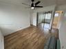 Wood-finish flooring, mirrored closet doors, ceiling fan with integrated lighting, and crown molding