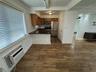 Kitchen featuring wood-finish flooring, dark stone countertops, wood cabinetry, stainless steel appliances, and ceiling crown molding
