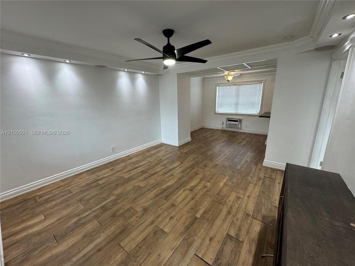 Interior space featuring wood-finish flooring, recessed ceiling accent lighting, a matte black multi-blade ceiling fan, and window blinds