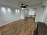 Interior space featuring wood-finish flooring, recessed ceiling accent lighting, a matte black multi-blade ceiling fan, and window blinds