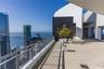 Expansive outdoor terrace featuring paved flooring, a metal safety railing, and high-contrast architectural wall elements