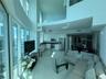Double-height living area featuring floor-to-ceiling glass windows, high-gloss kitchen cabinetry, stainless steel appliances, and interior glass mezza