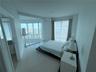 Floor-to-ceiling curved glass windows, expansive ceramic tile flooring, and neutral wall finishes