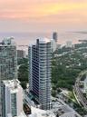 High-rise residential tower featuring a curved glass facade and a multi-level swimming pool terrace