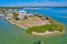 Waterfront parcel featuring extensive shoreline, concrete seawall, and mature palm trees
