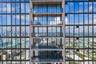 High-rise exterior featuring floor-to-ceiling glass windows and private balconies with glass railings