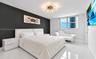 Room featuring high-gloss tile flooring, a charcoal-toned accent wall, and a multi-arm sputnik-style flush mount ceiling light