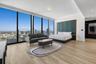 Floor-to-ceiling windows, wood-finish flooring, built-in paneling with integrated recessed lighting, and recessed ceiling lights