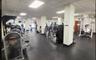 Expansive fitness center featuring recessed ceiling lighting, structural support columns, and durable rubberized flooring