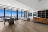 Floor-to-ceiling windows, wood-finish flooring, built-in shelving, recessed lighting, and a private balcony