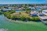 Waterfront property featuring a private wooden dock, extensive shoreline, mature palm trees, and native vegetation