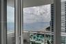 Private covered balcony featuring white railing and floor-to-ceiling glass sliding doors