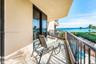 Covered balcony featuring tile flooring, metal railings, and sliding glass door entry
