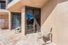 Covered patio featuring concrete paver flooring, dual sliding glass doors, and stucco exterior walls