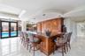 Custom wood cabinetry bar featuring a stone countertop, recessed ceiling lighting, pendant fixtures, and polished tile flooring
