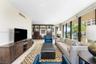 Living area featuring floor-to-ceiling glass sliding doors, built-in dark wood cabinetry, and neutral-toned flooring