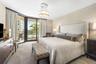 Floor-to-ceiling sliding glass doors, private balcony, patterned wall covering, carpeted flooring, and circular pendant lighting