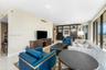 Open-concept interior featuring large-format stone flooring, floor-to-ceiling glass panel windows, and custom built-in dark wood shelving with integra
