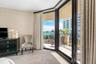 Floor-to-ceiling sliding glass doors, private balcony with metal railing, and patterned wall covering