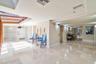 Polished stone flooring, recessed ceiling lighting, wall-mounted light fixtures, and a decorative recessed niche with textured detailing
