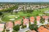 Aerial perspective of a multi-gabled residence featuring a concrete tile roof, skylight, enclosed lanai, and frontage along a golf course