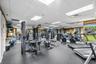 Fitness center featuring rubber flooring, mirrored walls, drop ceiling panels, and floor-to-ceiling windows